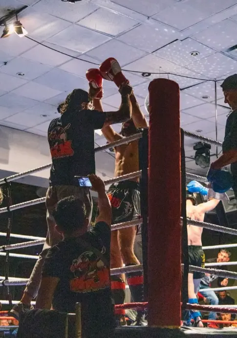 An arm raised in victory in the ring corner